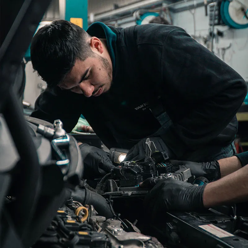 Technician inspecting a vehicle engine
